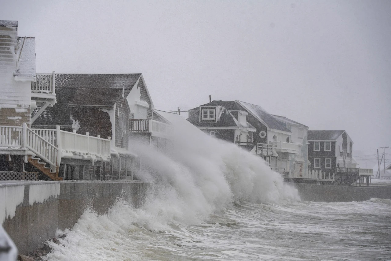 High waves pound houses on the shoreline of Massachusetts.