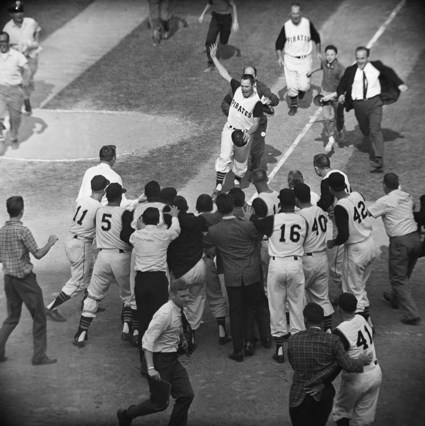 Bill Mazeroski chased by a fan gets ready to cross home plate and is greeted by fans and fellow players after his ninth inning homer in the World Series on October 13, 1960.