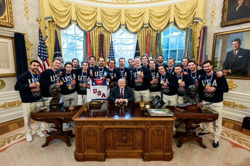 President Donald Trump poses with the US men's hockey team in the White House Oval Office.
