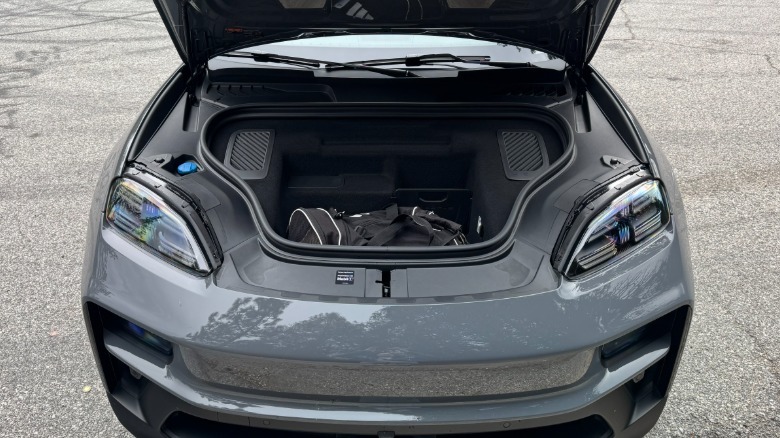 An under-hood shot of the Slate Grey Neo Macan GTS showing the frunk with a black duffel bag in it