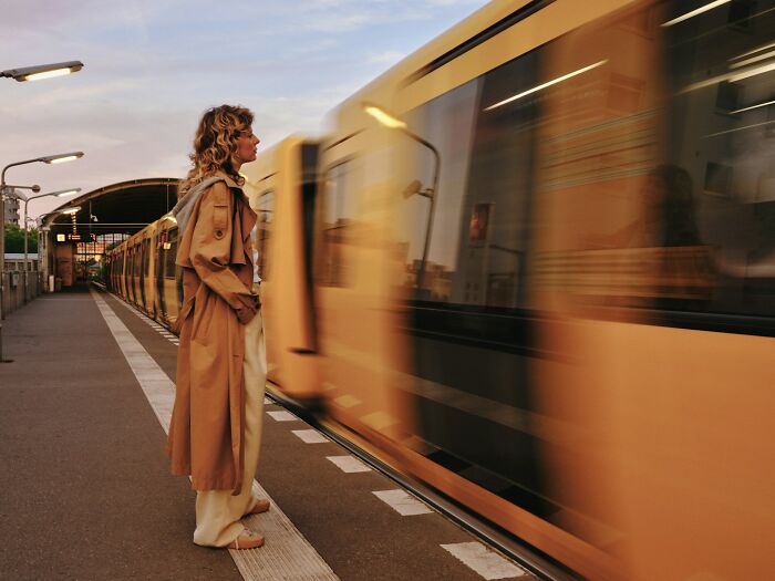 Woman standing on train platform appearing deep in thought, illustrating daily worries women face contrasted with peaceful bliss.