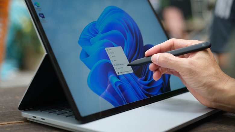 Someone using a stylus in Windows 11 to interact with the context menu.