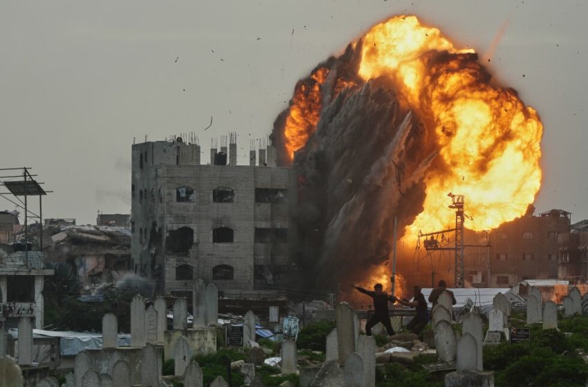  Photos show an Israeli airstrike in detail while men take cover in a graveyard