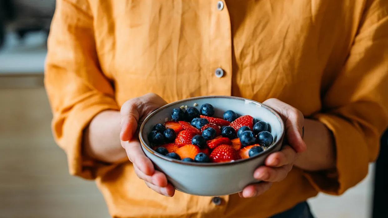 woman holds bowl of berries