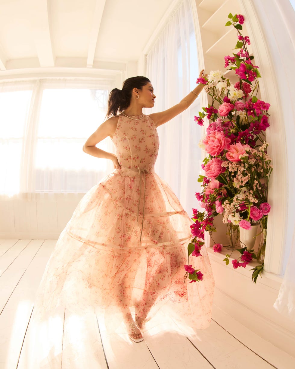 woman in a floral dress interacting with a floral arrangement