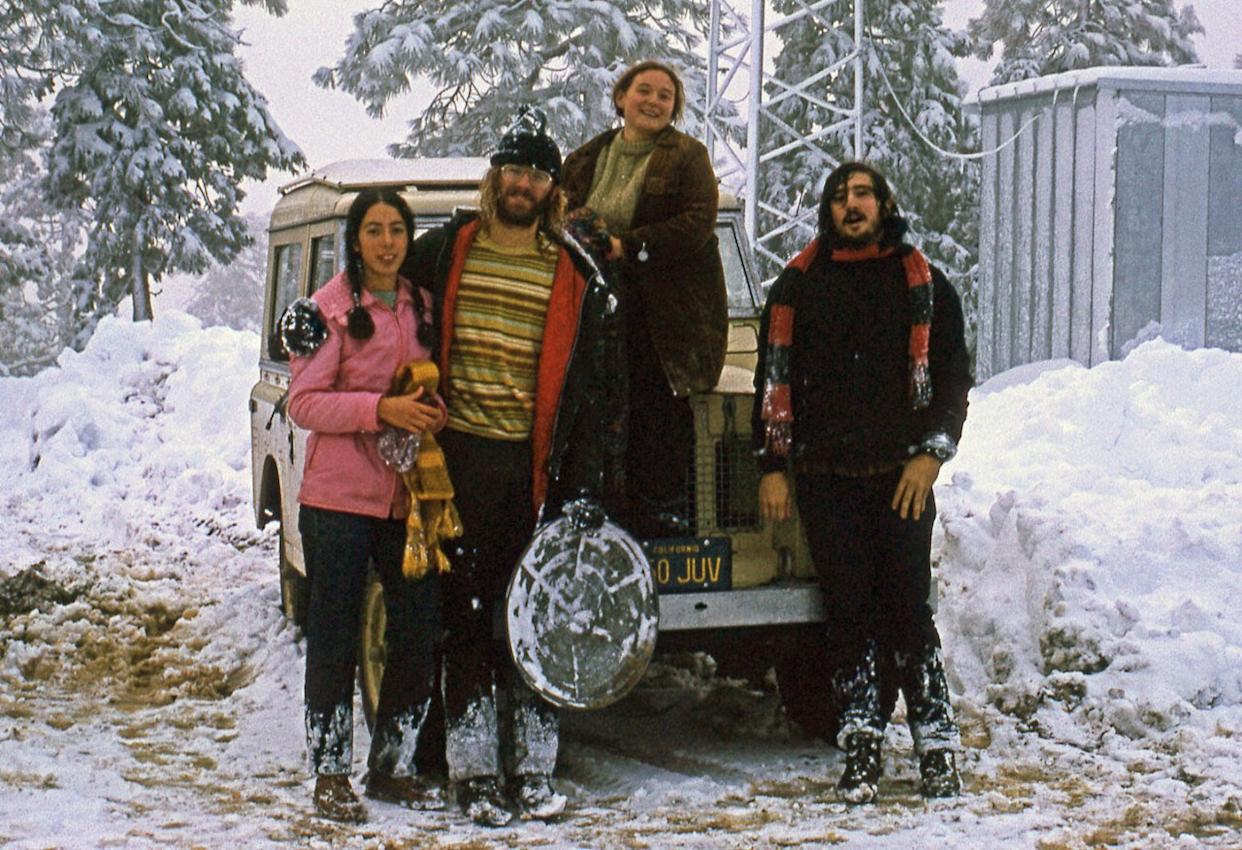 Four friends standing around in the snow -