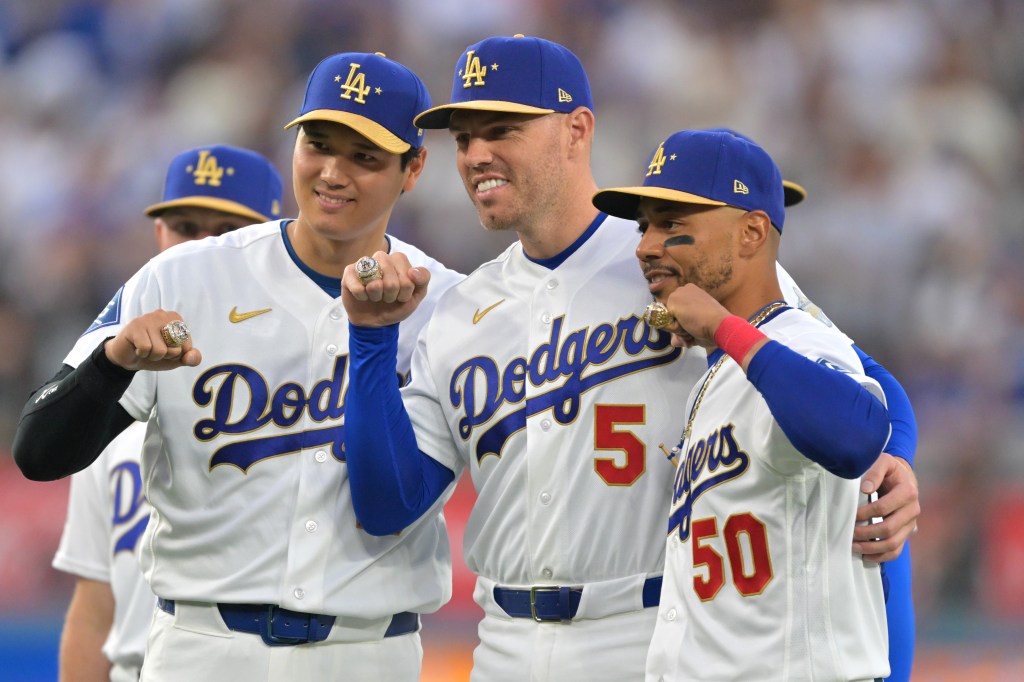 Los Angeles Dodgers players Shohei Ohtani, Freddie Freeman, and Mookie Betts posing during the World Series ring ceremony.