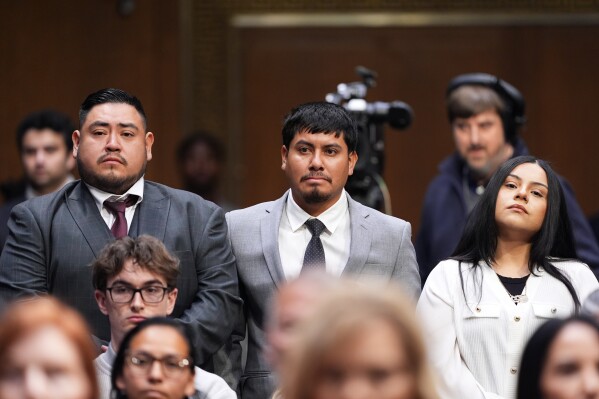 Three U.S. citizens who had been detained by ICE from left, Javier Ramirez of Calif., Leonardo “Leo” Garcia Venegas of Ala., and Marimar Martinez of Chicago, stand and are introduced by Sen. Richard Blumenthal, D-Ct., as Homeland Security Secretary Kristi Noem appears for an oversight hearing before the Senate Judiciary Committee, at the Capitol in Washington, Tuesday, March 3, 2026. (AP Photo/J. Scott Applewhite)