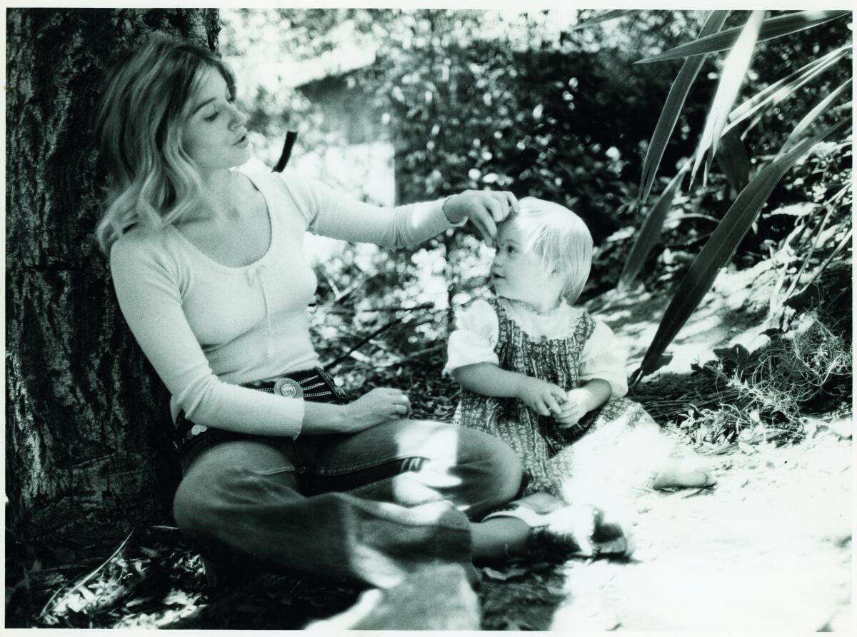 A black and white photo of Christina Applegate as a baby with her mother.