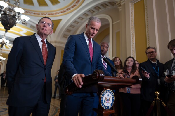Senate Majority Leader John Thune, R-S.D., center, joined at left by Sen. John Barrasso, R-Wyo., the GOP whip, speaks to reporters at the Capitol in Washington, Tuesday, March 3, 2026. (AP Photo/J. Scott Applewhite)