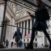 People walk by the New York Stock Exchange on Wall Street.
