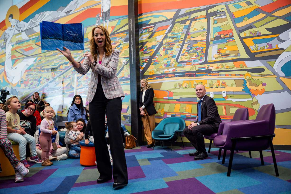 Gov. Spencer Cox, right, smiles as first lady Abby Cox reads to children at after a press conference discussing the fiscal year 2026-27 budget rollout at Kearns Library in Kearns on Dec. 3, 2025.