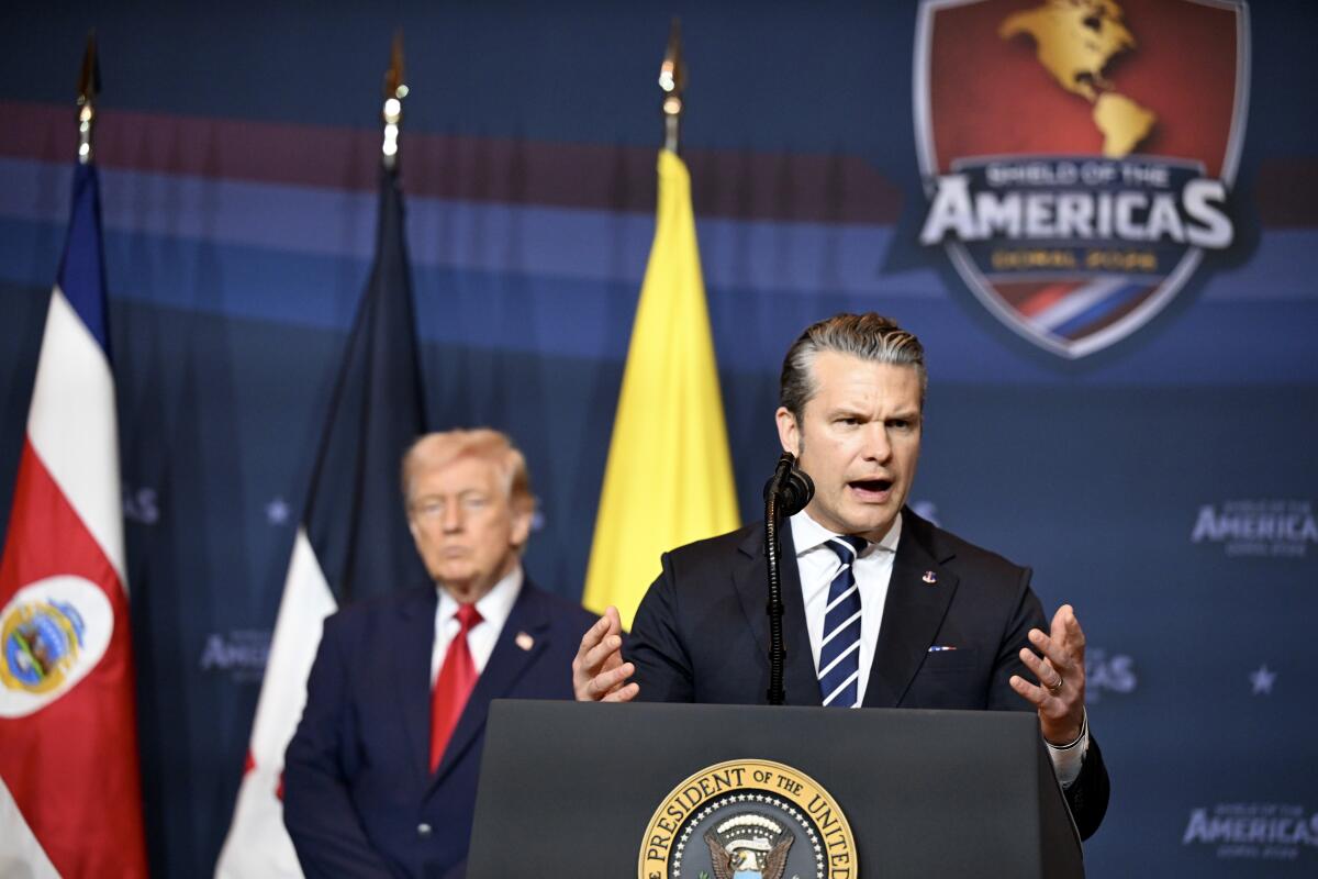 Defense Secretary Pete Hegseth addresses the audience as President  Trump listens