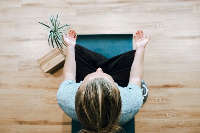 Overhead shot of a light-skinned woman meditating. 