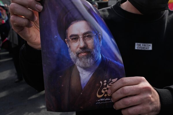 A man holds a poster of Ayatollah Mojtaba Khamenei, the successor to his late father Ayatollah Ali Khamenei as supreme leader, during a rally to support him in Tehran, Iran, Monday, March 9, 2026. (AP Photo/Vahid Salemi)