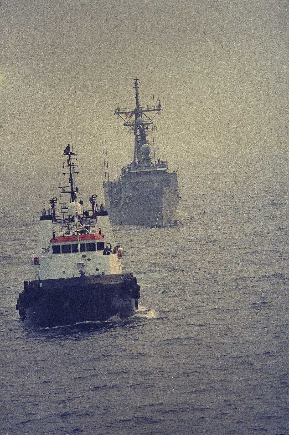 A Kuwaiti minesweeping tug tows the crippled USS Samuel B. Roberts towards Dubai after it struck a mine, April 15, 1988.