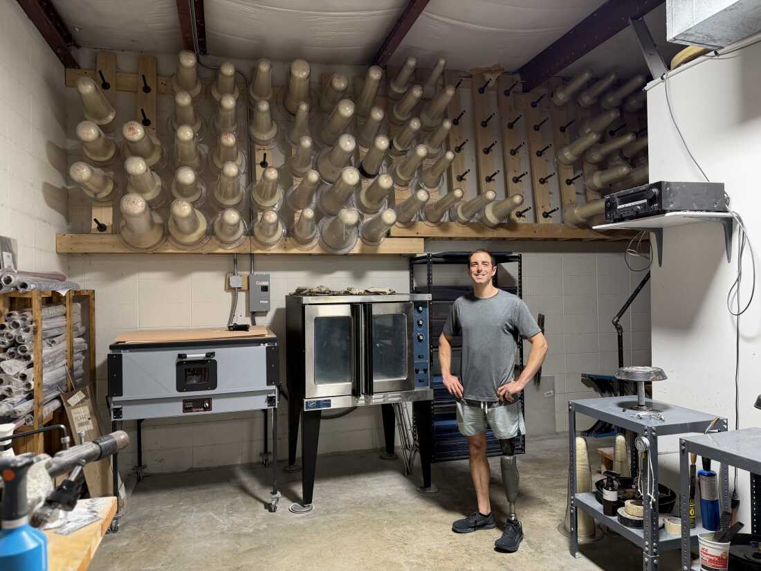 Ronnie Dickson stands in front of leg molds in his Chattanooga, Tenn. workshop. An amputee and prosthetist, he's working with several athletes who hope to compete in the 2028 Summer Paralympics.