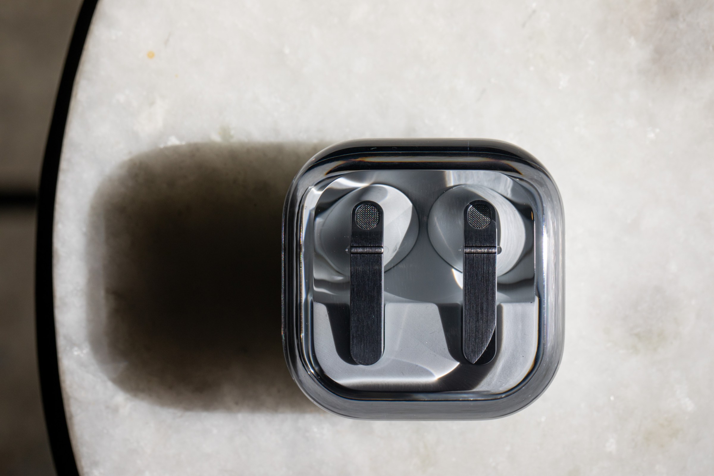 The Samsung Galaxy Buds 4 Pro in their charging case on a white tabletop.