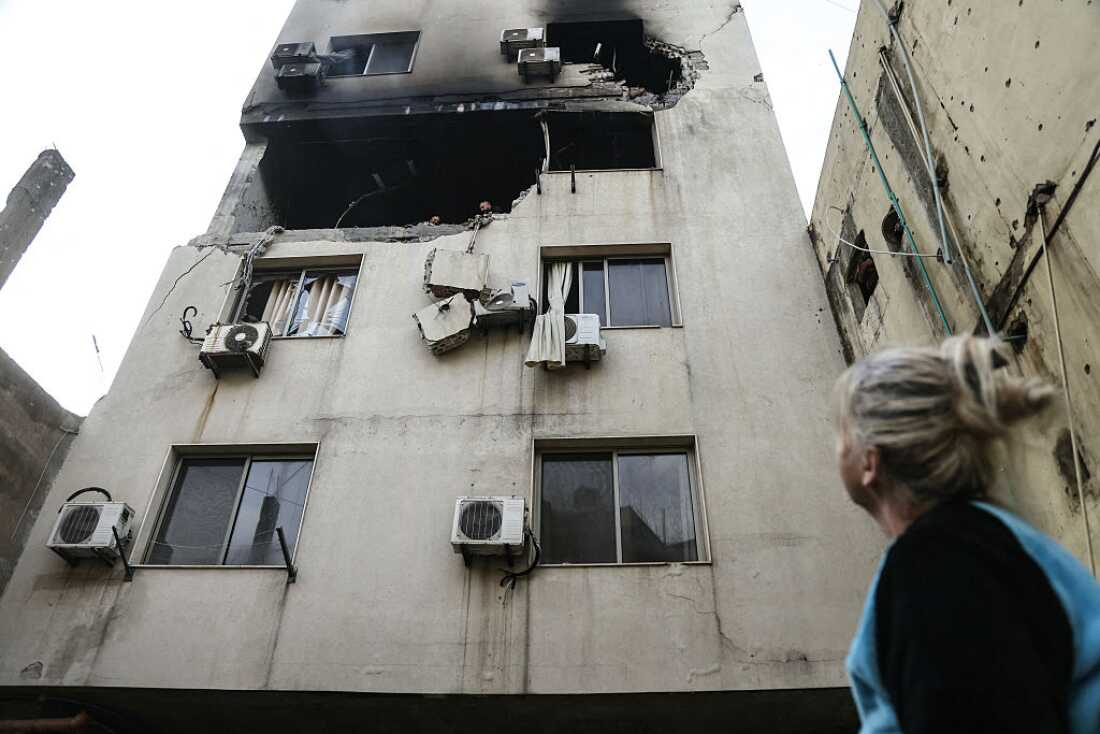 A woman looks at a building where an apartment was targeted by an Israeli airstrike in the Burj Hammoud area on the northern outskirts of Beirut on March 14, 2026.