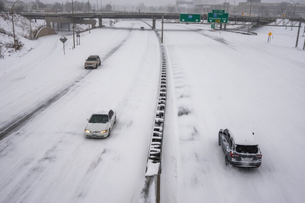 People drive on a snow-covered freeway during a snow storm Sunday, March 15, 2026, in Minneapolis. (Richard Tsong-Taatarii/Minnesota Star Tribune via AP)