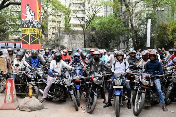 Motorists wait behind a rope for their turn to get fuel at a pump, fearing a possible fuel shortage due to the Iran war, in Dhaka, Bangladesh, Sunday, March 8, 2026. (AP Photo/Mahmud Hossain Opu, File)