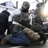 Federal immigration officers detain a person observing them on Jan. 13, 2026, in Minneapolis. After being arrested, some protesters have said federal officers took samples of their DNA.