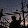 People place flowers on a fence outside Krome Detention Center in Miami in May 2025, during a vigil to recognize people who have died in U.S. Immigration and Customs Enforcement custody as well as those affected by mass deportations.