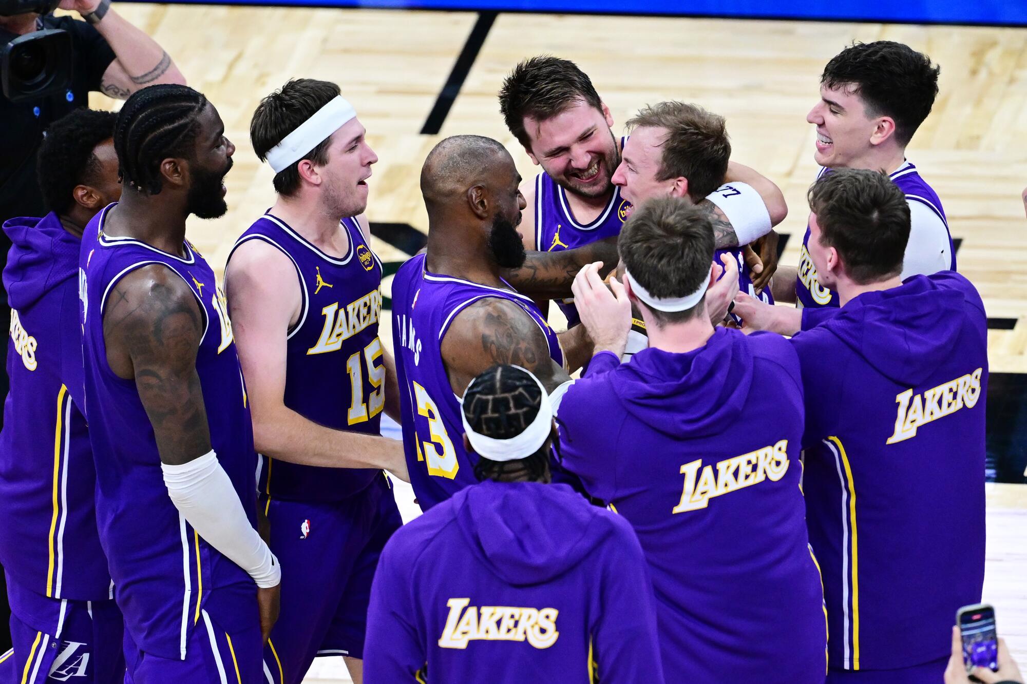 Lakers players surround guard Luke Kennard.