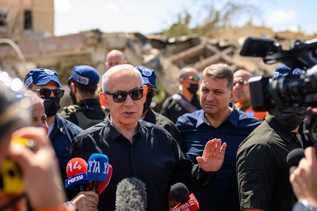 Israeli Prime Minister Benjamin (Bibi) Netanyahu, accompanied by Dimona Mayor, Benny Biton (L), speak to media while visiting the area destroyed by an Iranian ballistic missile last night, leaving over 50 wounded residents on March 22, 2026 in Dimona, Israel.