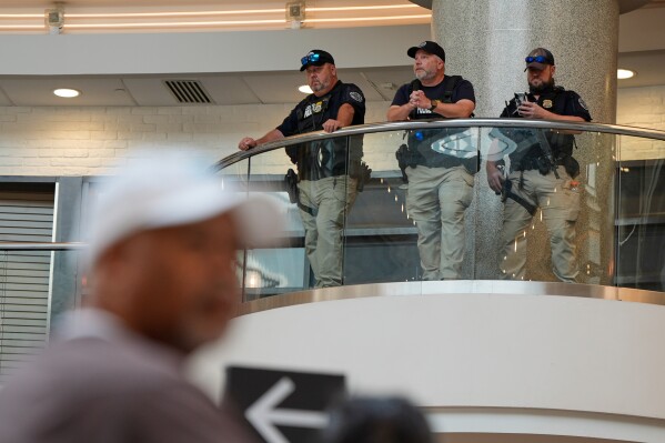 Federal immigration agents are seen at the Hartsfield-Jackson Atlanta International Airport, Monday, March 23, 2026, in Atlanta. (AP Photo/Mike Stewart)