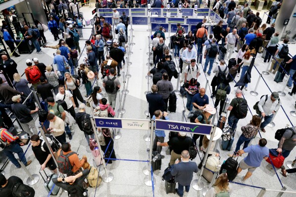 Air travelers progress through the long lines for the TSA security checkpoint in Terminal C at the George Bush Intercontinental Airport, Monday, March 23, 2026, in Houston. (AP Photo/Michael Wyke)