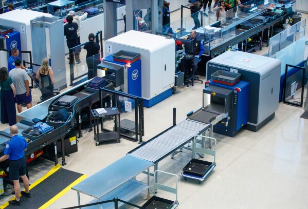 Travelers wait in line as several screening lines are closed at Louis Armstrong International Airport in Kenner, La. Monday, March 23, 2026. (David Grunfeld/The New Orleans Advocate via AP)