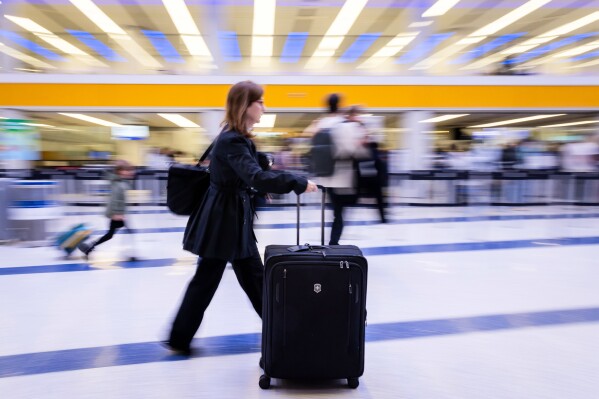 A traveler walks inside a terminal at Los Angeles International Airport on Monday, March 23, 2026, in Los Angeles. (AP Photo/Ethan Swope)