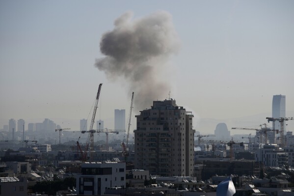 Smoke billows following an Iranian missile strike in Tel Aviv, Tuesday, March 24, 2026. (AP Photo/Ohad Zwigenberg)