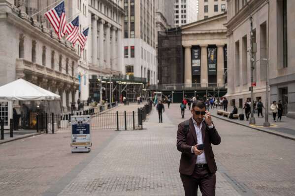 A person walks past the New York Stock Exchange, Friday, March 27, 2026, in New York. (AP Photo/Yuki Iwamura)