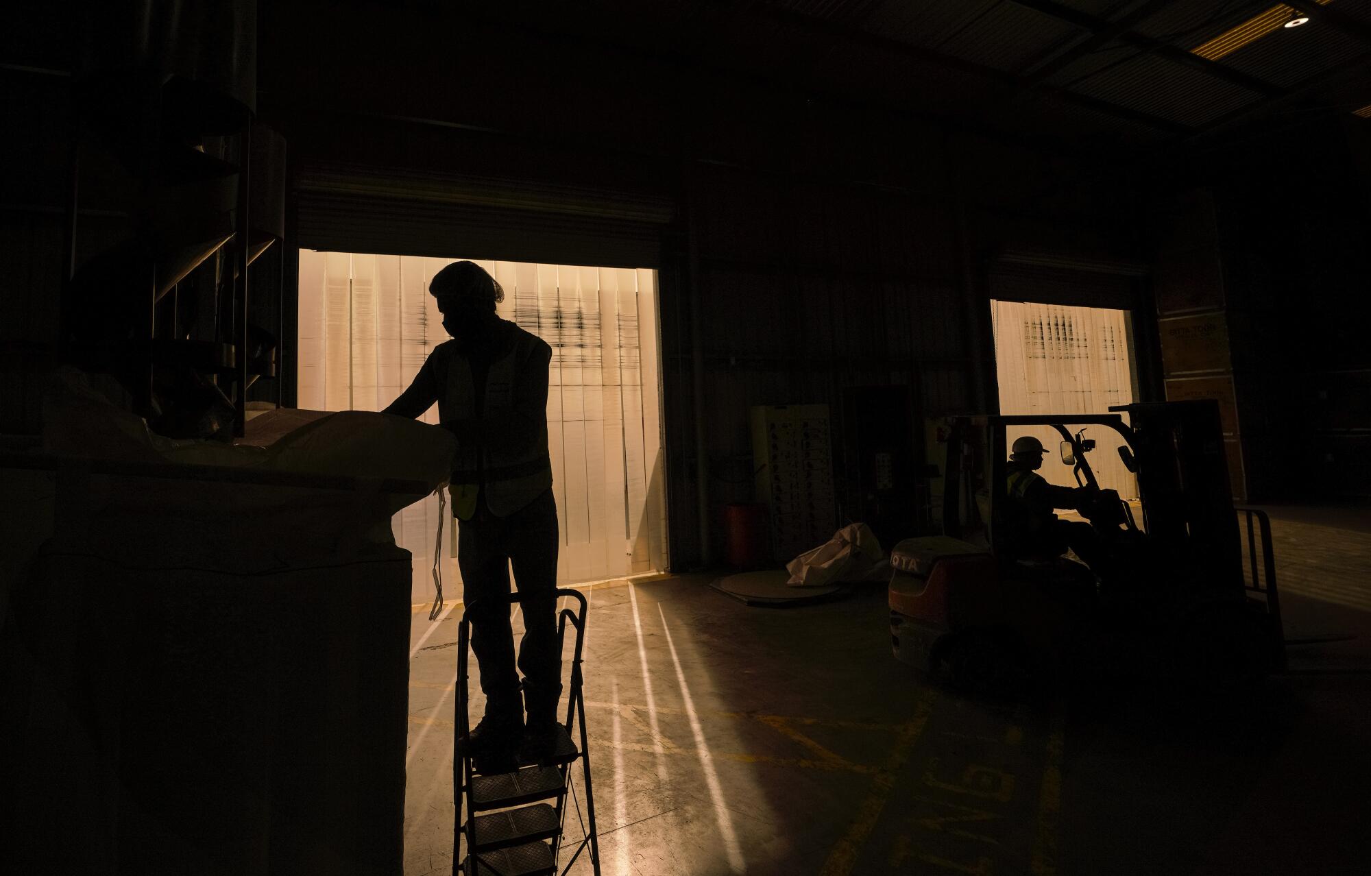 an employee at Sequoia Nut Company and Custom Almonds LLC loads almonds into bulk bags