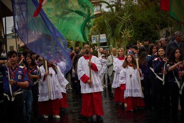 Worshipers walk in a procession during a Palm Sunday Mass at the Our Lady of Hadat Church in Beirut, Lebanon, Sunday, March 29, 2026. (AP Photo/Emilio Morenatti)
