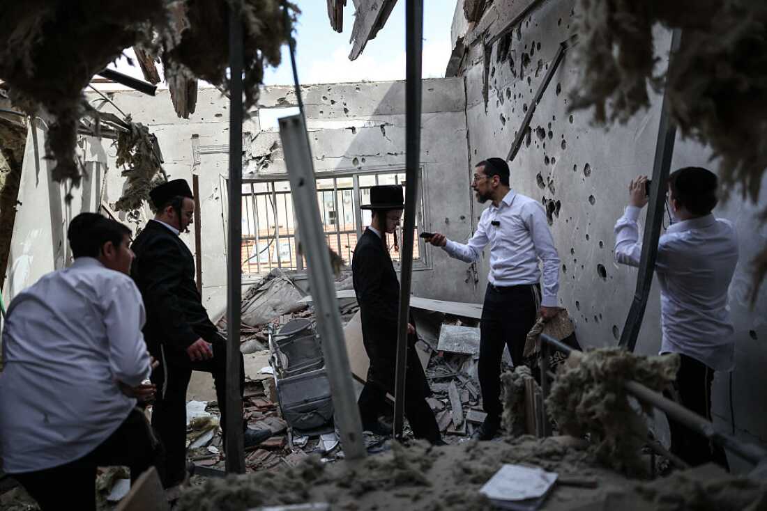 Ultra-Orthodox Jews stand inside a damaged house following an Iranian strike over Bnei Brak in central Israel on March 31, 2026.