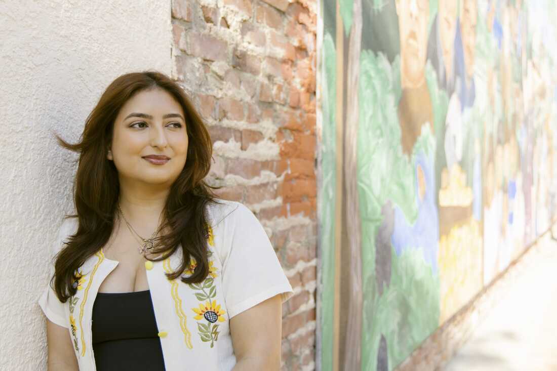 Monike Reynozo, associate director of programs for the non-profit Loud for Tomorrow, stands in front of a mural depicting Cesar Chavez and other leaders of the farm labor movement in downtown Delano, Calif. on March 29, 2026. Chavez formed the United Farm Workers labor union in Delano, but following the sexual abuse allegations locals like Reynozo no longer believe he needs to be a part of the mural.