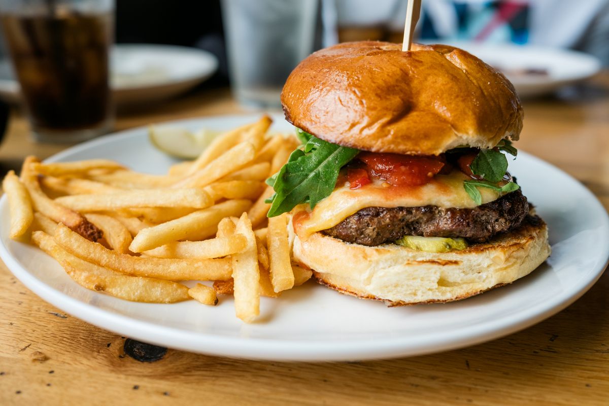 Close-up of cheeseburger and french fries on table at restaurant