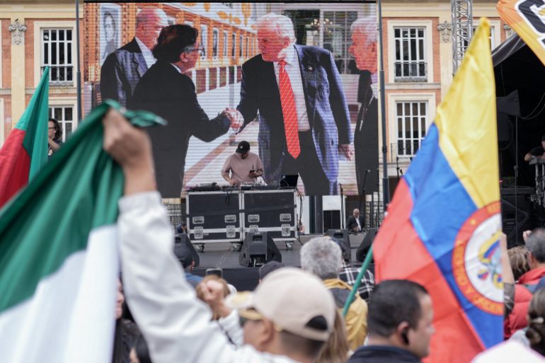 A screen shows Colombian President Gustavo Petro and U.S. President Donald Trump shaking hands, as people attend a rally, called by the Colombian government, in support of Petro during his ongoing visit to the U.S., at Plaza Bolivar in Bogota, Colombia, February 3, 2026. REUTERS/Nathalia Angarita