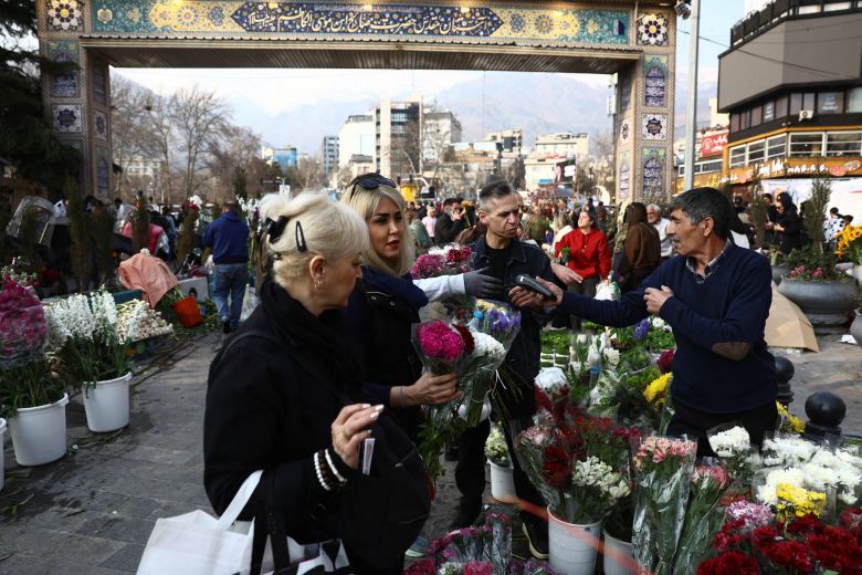 Iranian people shop for flowers and other goods on Thursday ahead of Nowruz, the Iranian New Year.