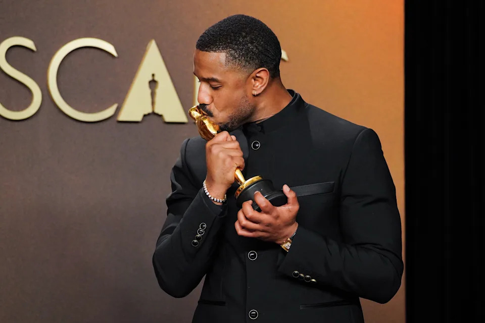 Michael B. Jordan kisses his trophy.