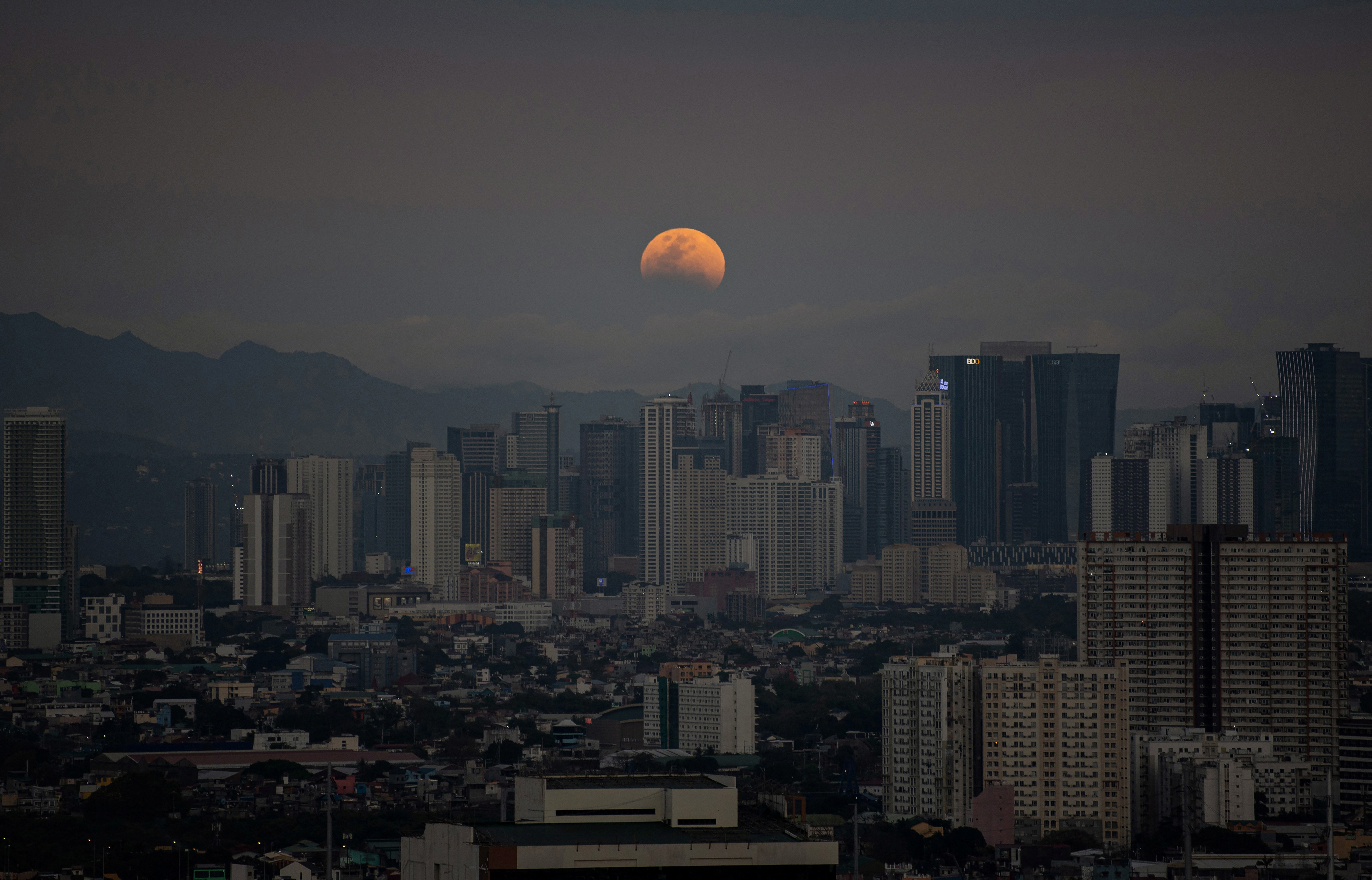 The 'blood moon' rises over the skyline of Manila, Philippines on Tuesday morning.