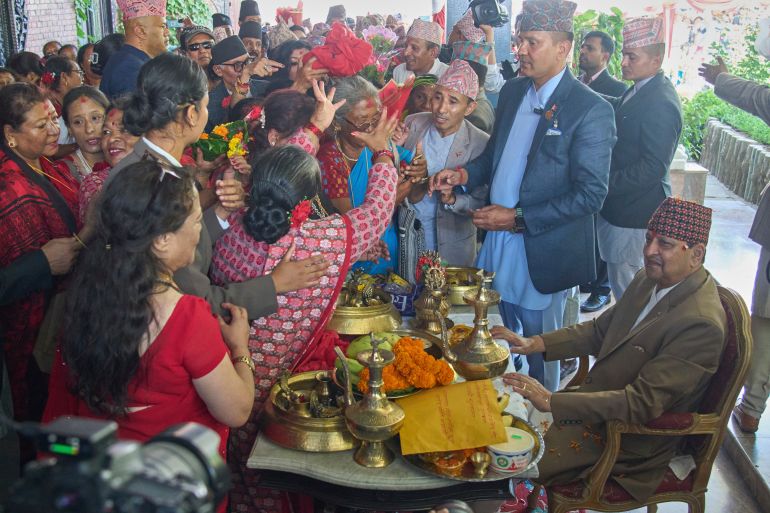 Supporters perform birthday rituals for former King Gyanendra Shah, sitting at right, at his residence in Kathmandu, Nepal, Monday, July 7, 2025. (AP Photo/Niranjan Shrestha)