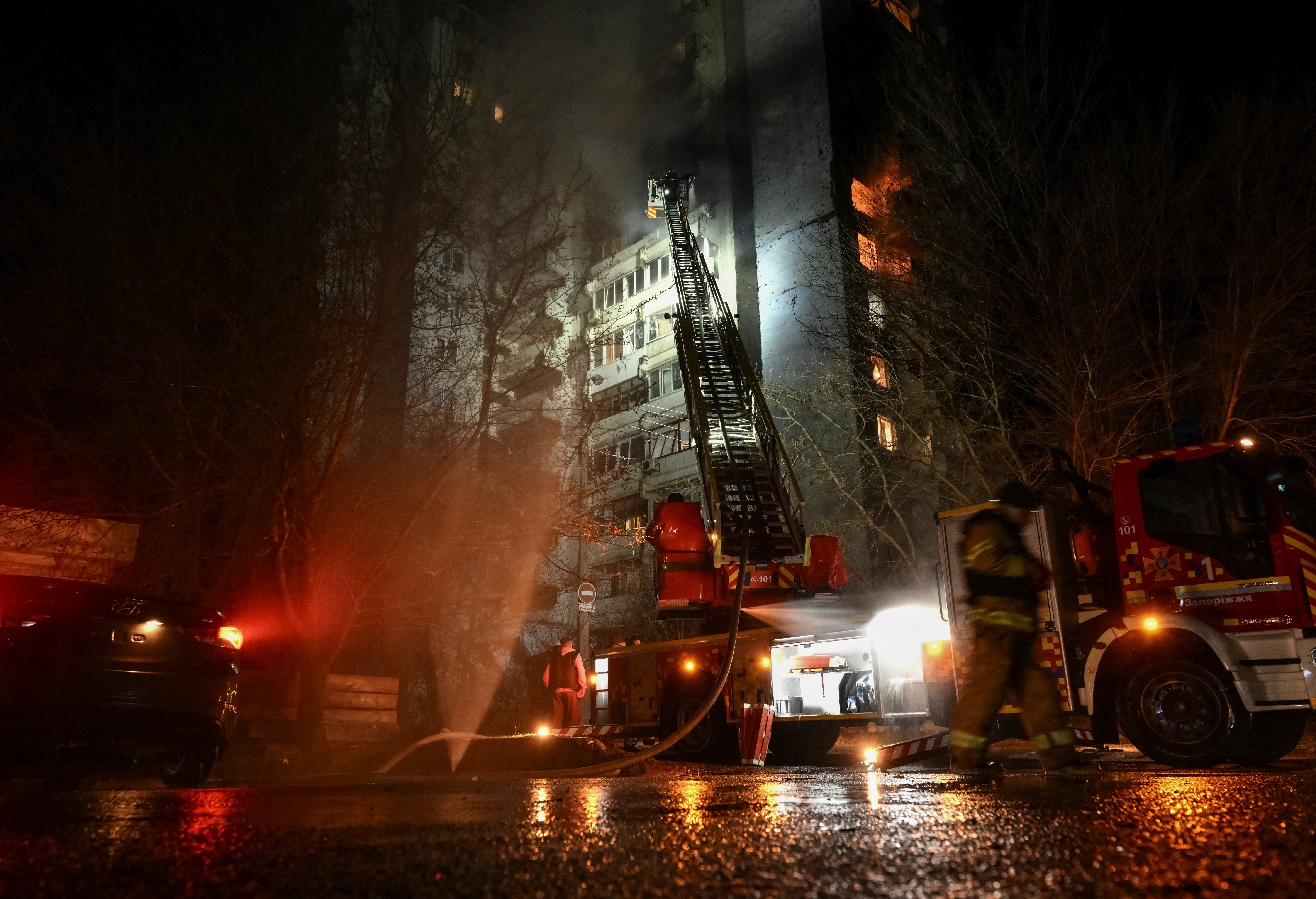 Firefighters work at the site of an apartment building hit by a Russian drone strike in Zaporizhzhia, Ukraine