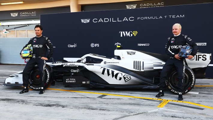 Sergio Perez of Mexico and Cadillac F1 Team and Valtteri Bottas of Finland and Cadillac F1 Team pose for a photo with the car in the Pitlane during day one of F1 Testing at Bahrain International Circuit on February 11, 2026 in Bahrain, Bahrain.