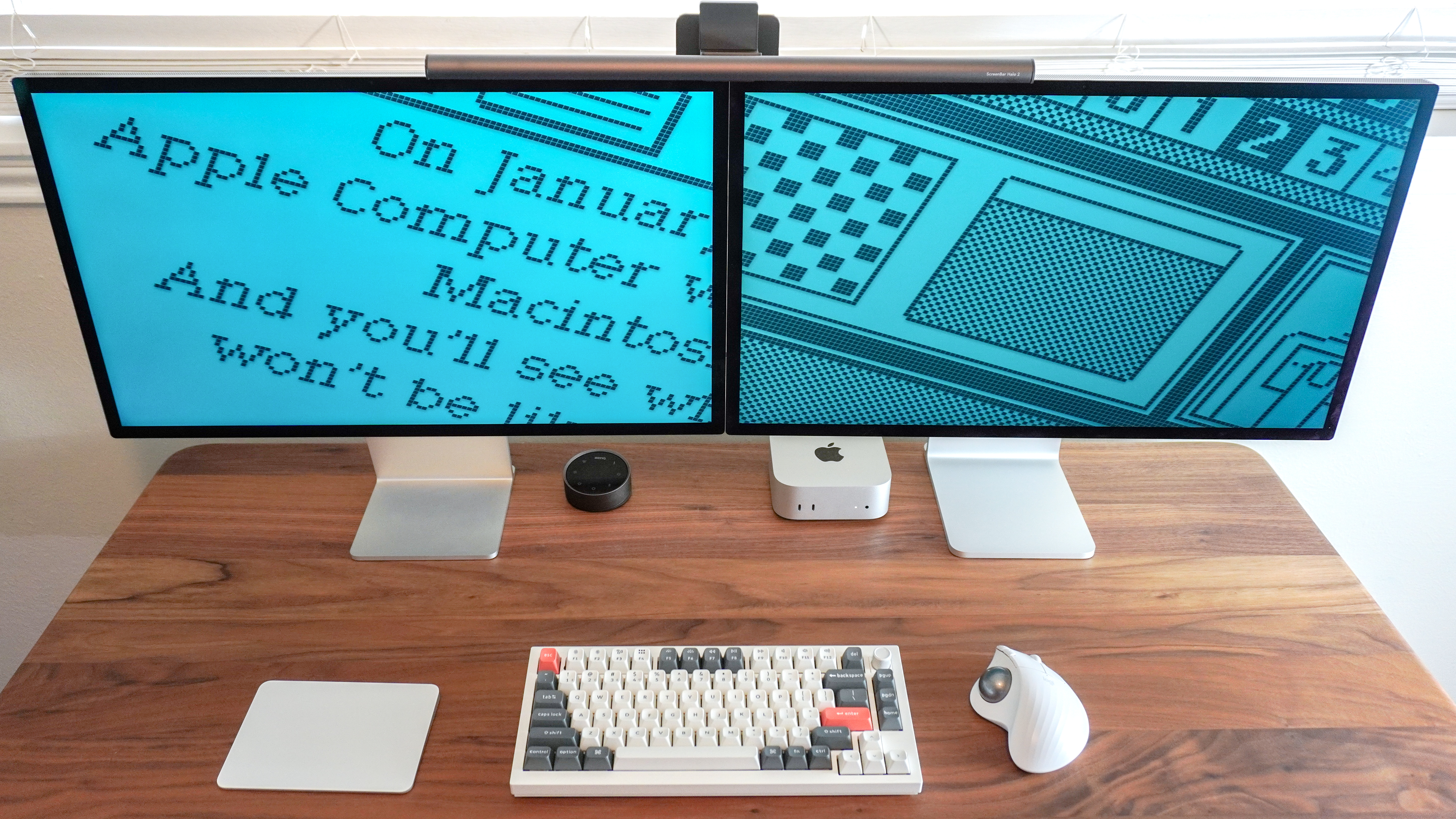 Apple's original Studio Display and its new Studio Display XDR side by side in a dual-monitor setup showing a screensaver