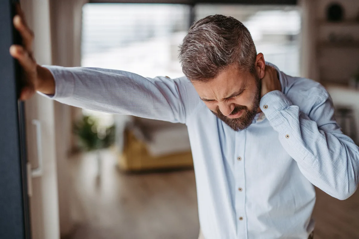 Man rubbing his neck in pain