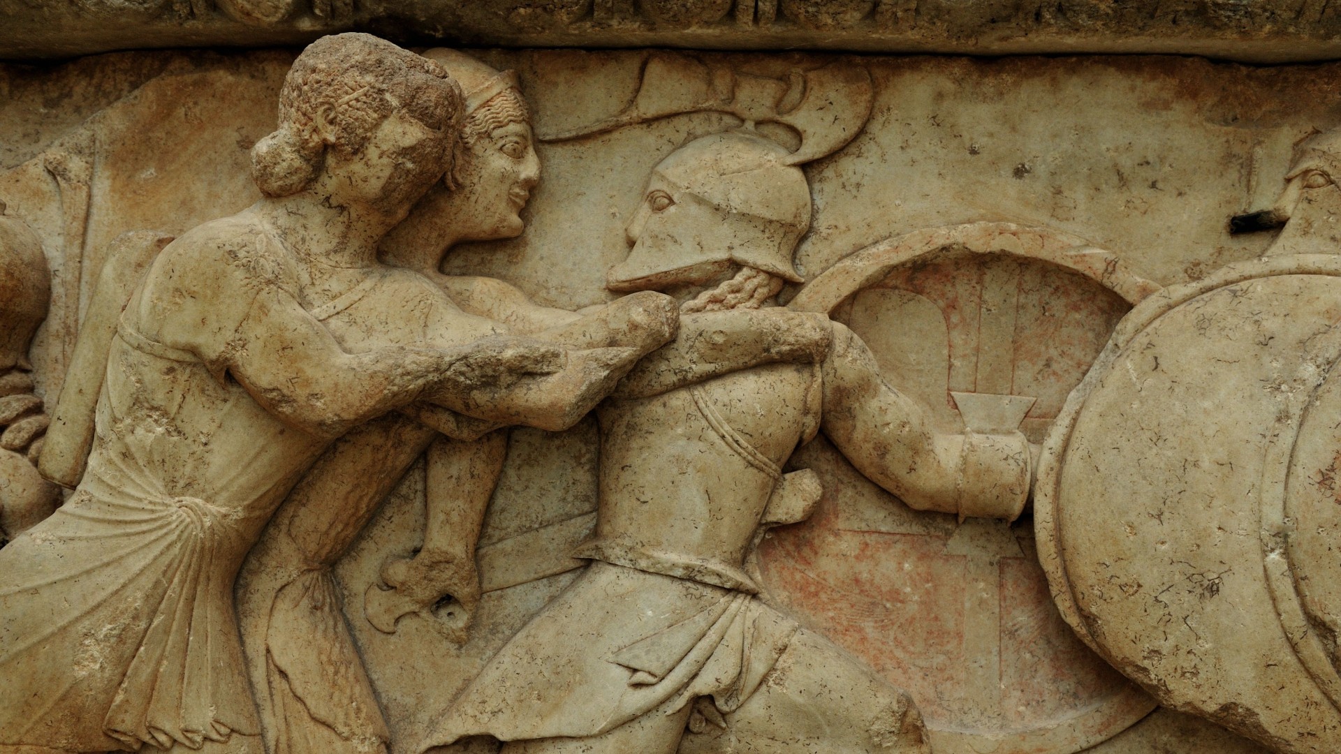 a relief of two human figures attacking a third figure wearing armor